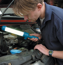 Mechanic working on car with flouro light